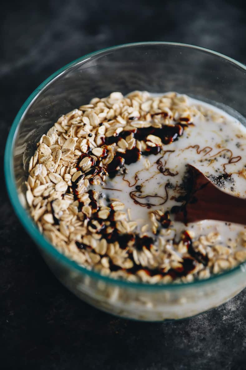 Mixture of gingerbread overnight oats in clear bowl before soaking overnight.