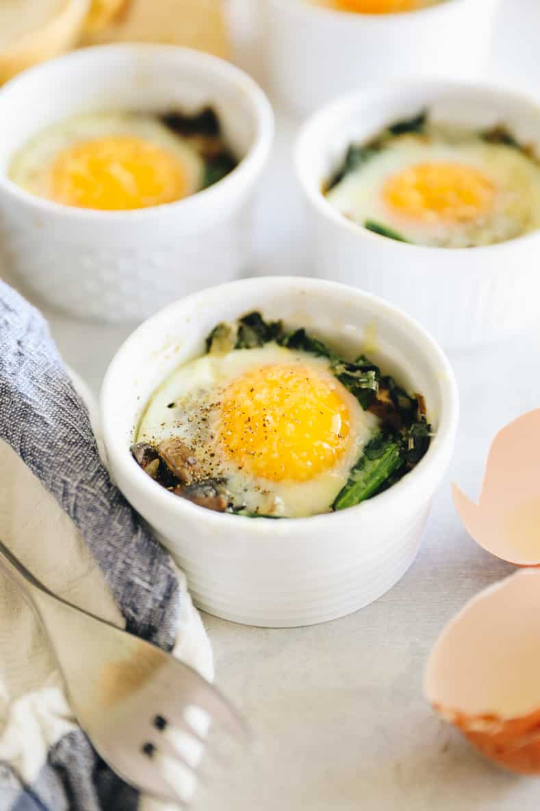 Three ramekins with vegetables and eggs baked inside.