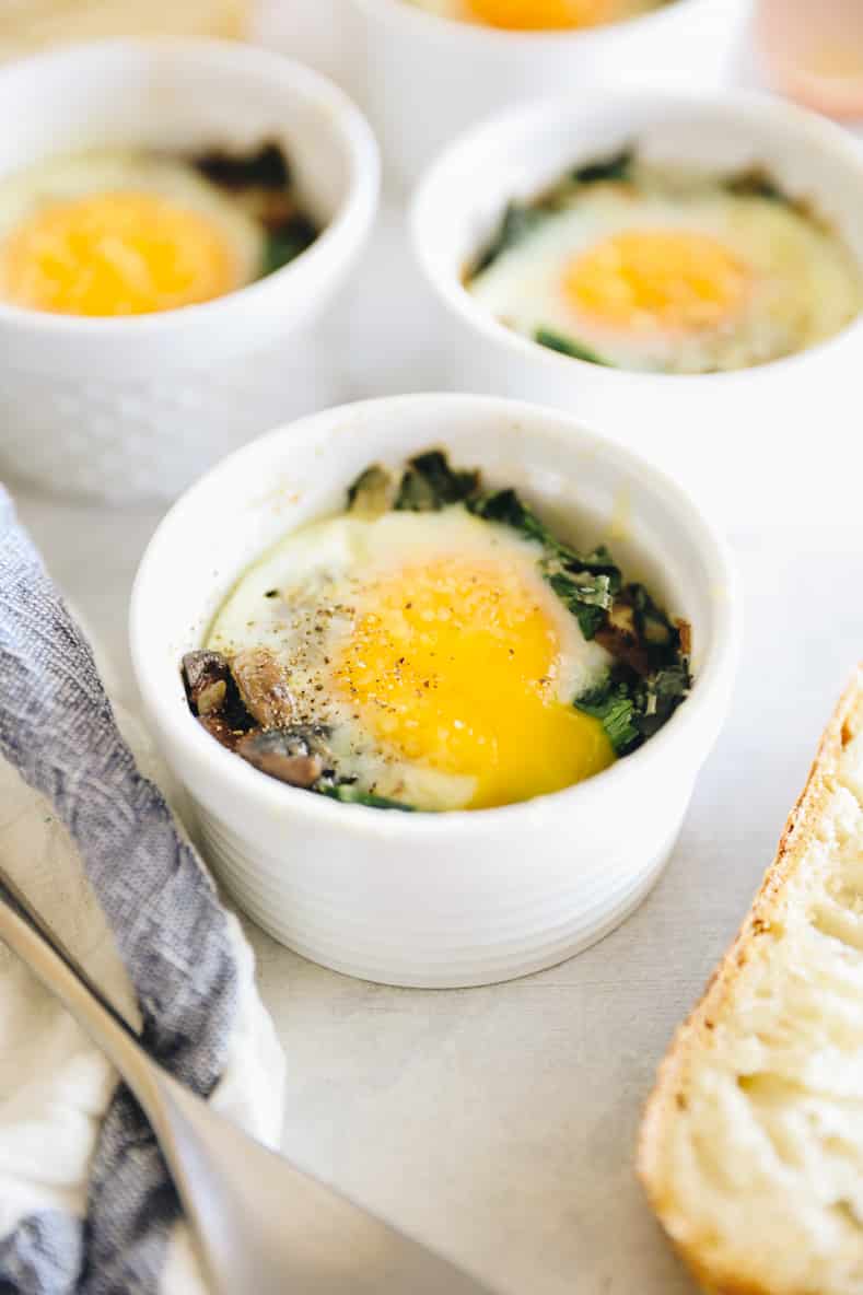Three ramekins with vegetables and eggs baked inside.