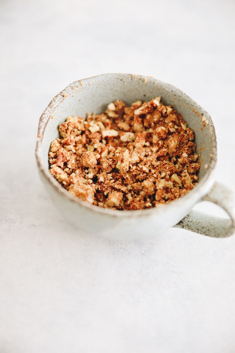Pecan streusel in a small blue cup.