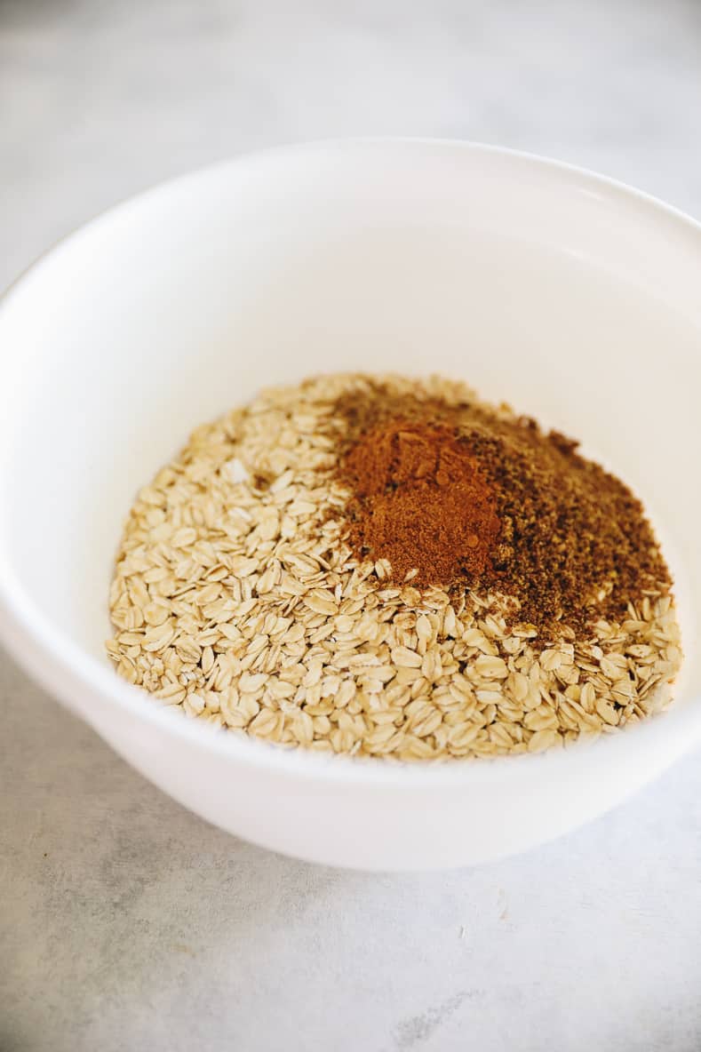 White mixing bowl with oatmeal and spices.