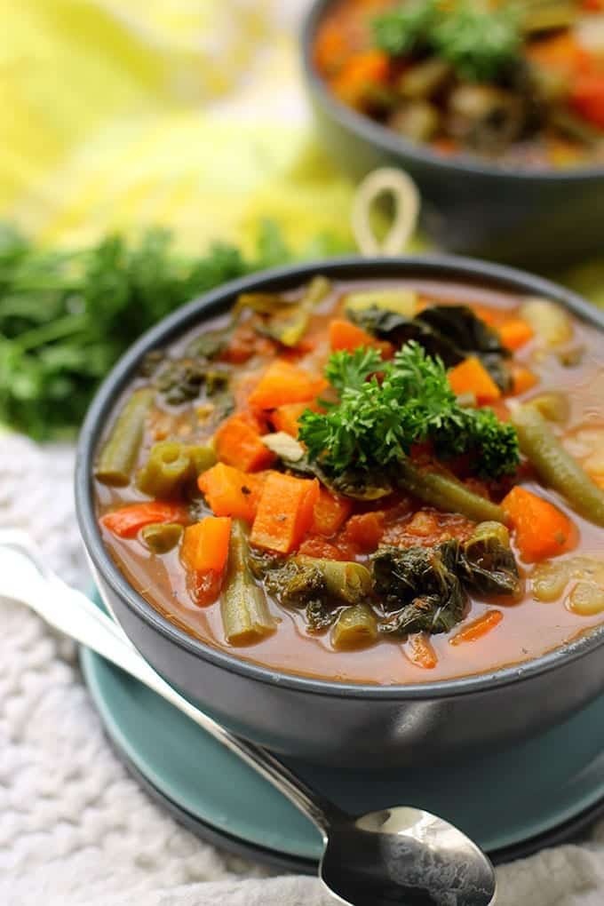 up-close image of easy vegetable soup with carrots, green beans, kale and bell peppers.
