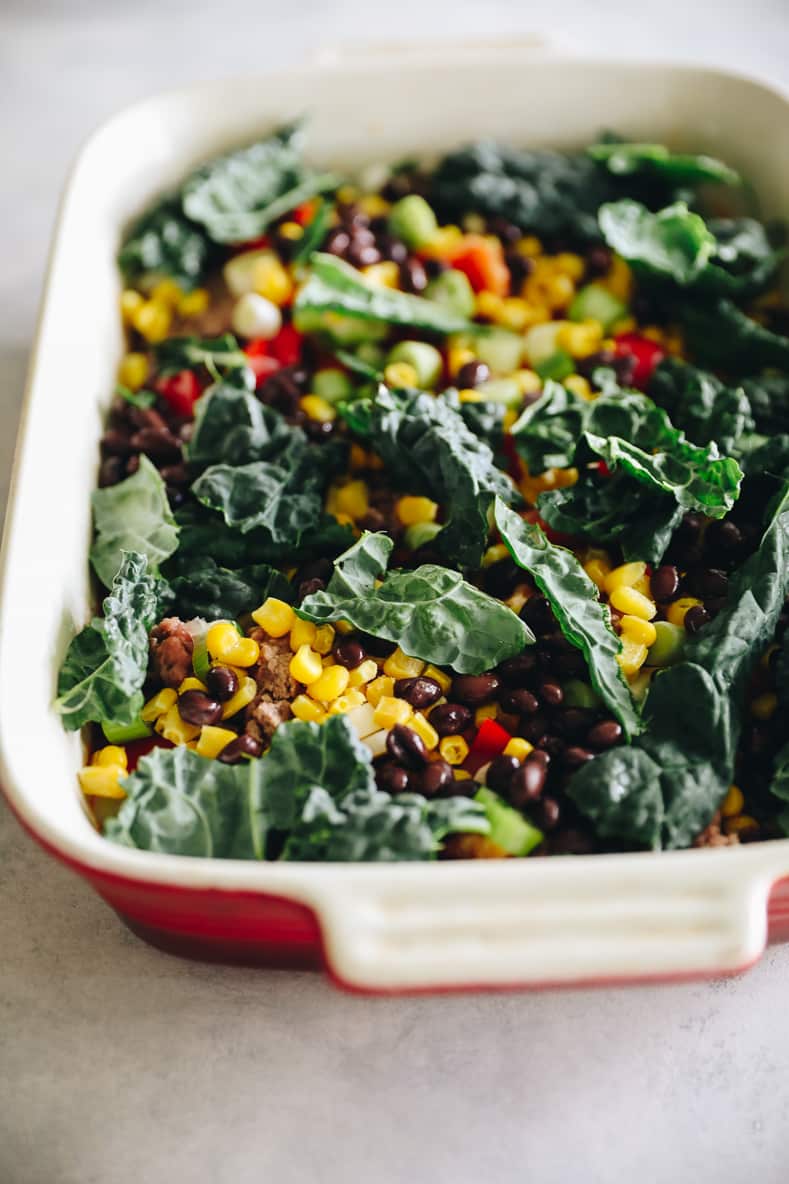 Angled shot of a quinoa taco casserole in a baking dish before layering on the cheese and baking.