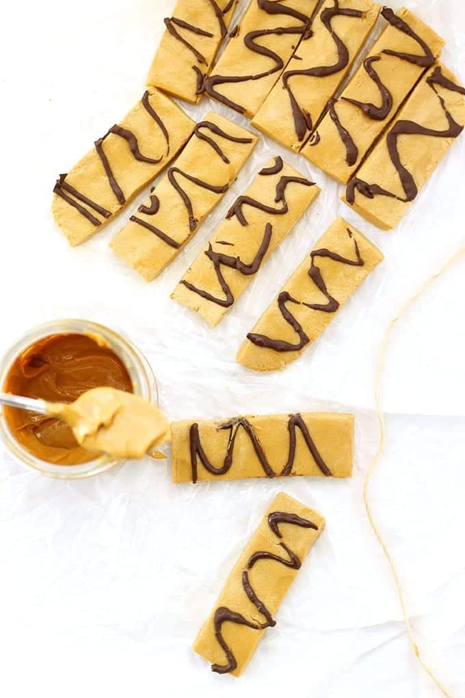 Overhead photo of peanut butter protein bars with a jar of peanut butter and a spoon