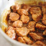 Sticky orange chicken cooking in saucepan.