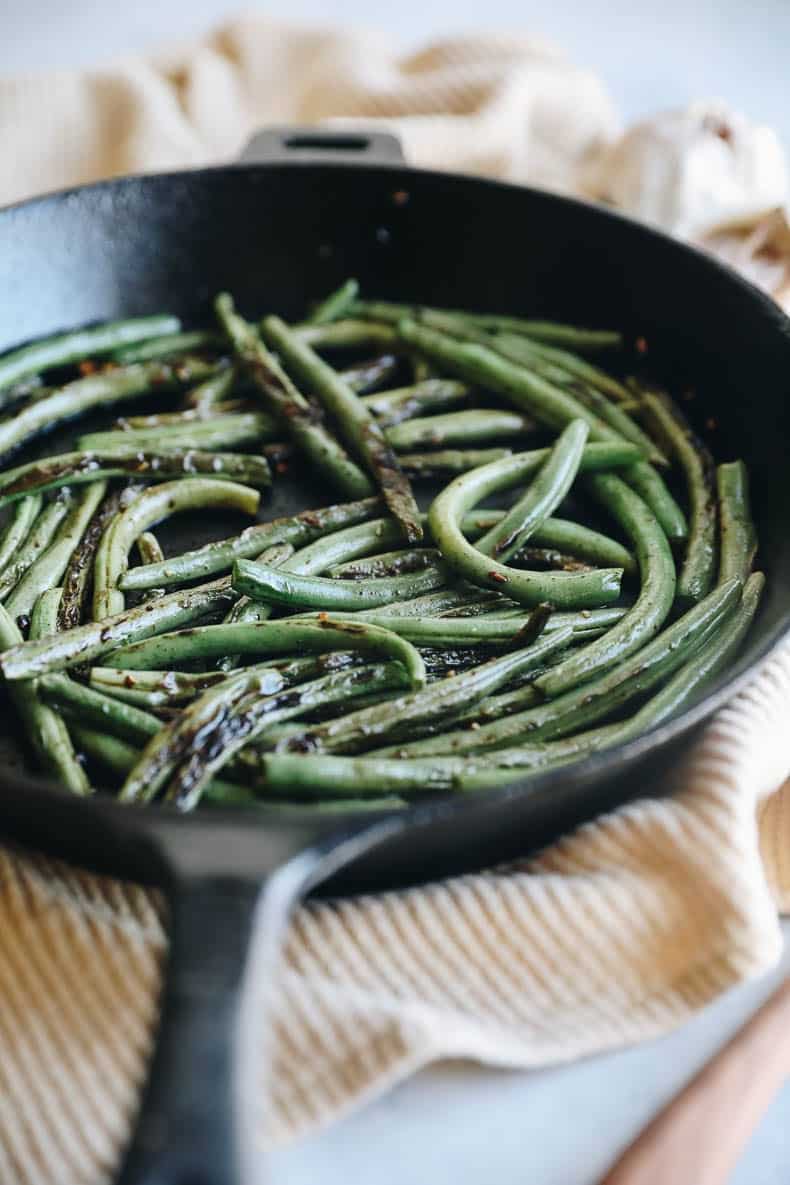charred green beans in a cast-iron skillet