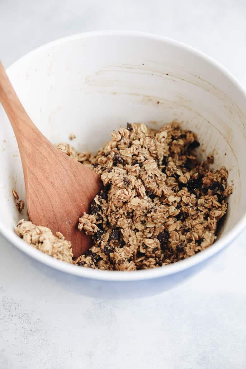 Large mixing bowl with energy ball mixture and a wooden spoon.