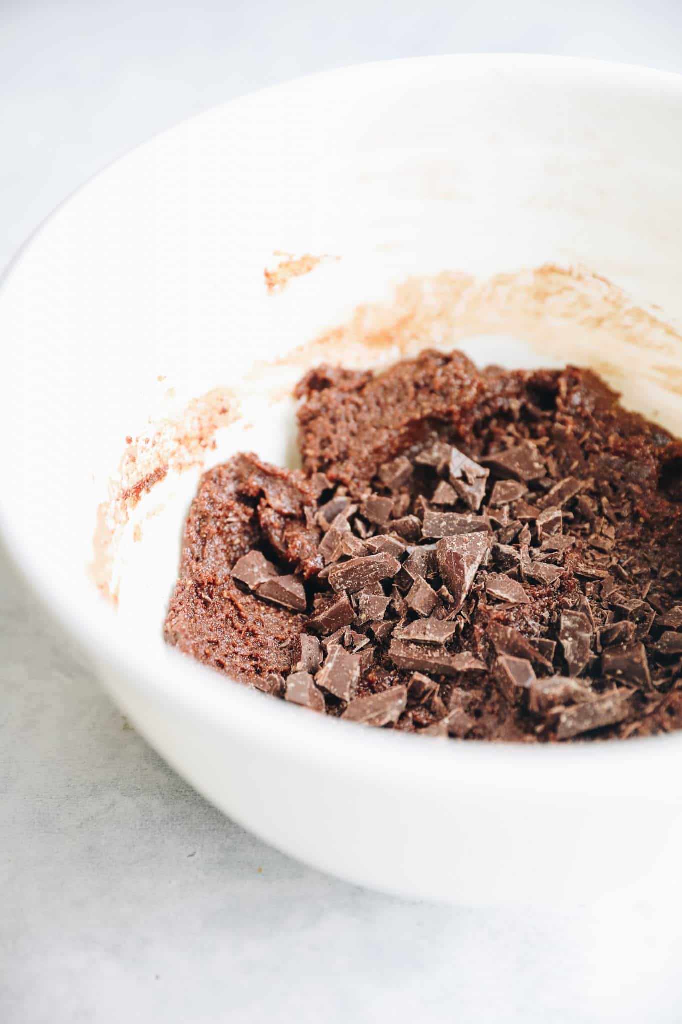 White mixing bowl with double chocolate cookie dough inside.