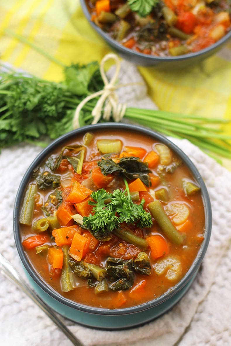 vegetable soup recipe in a blue bowl topped with fresh parsley