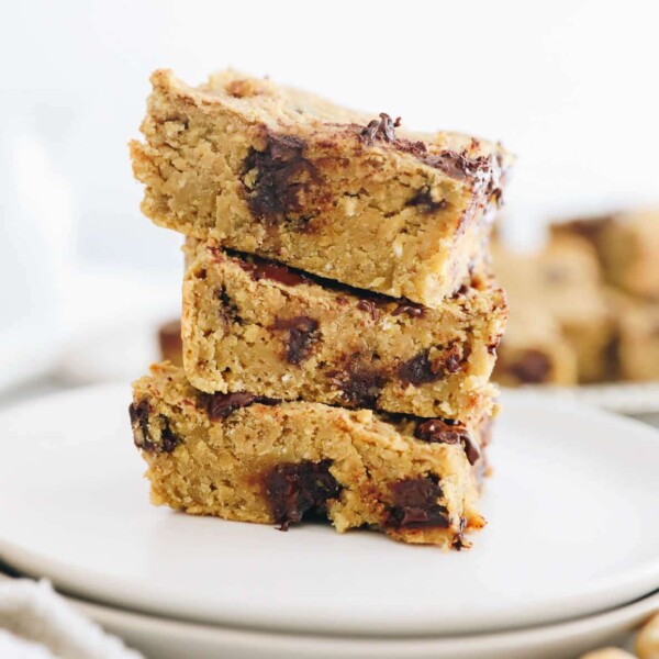 3 chickpea blondies stacked on top of each other on a white plate.