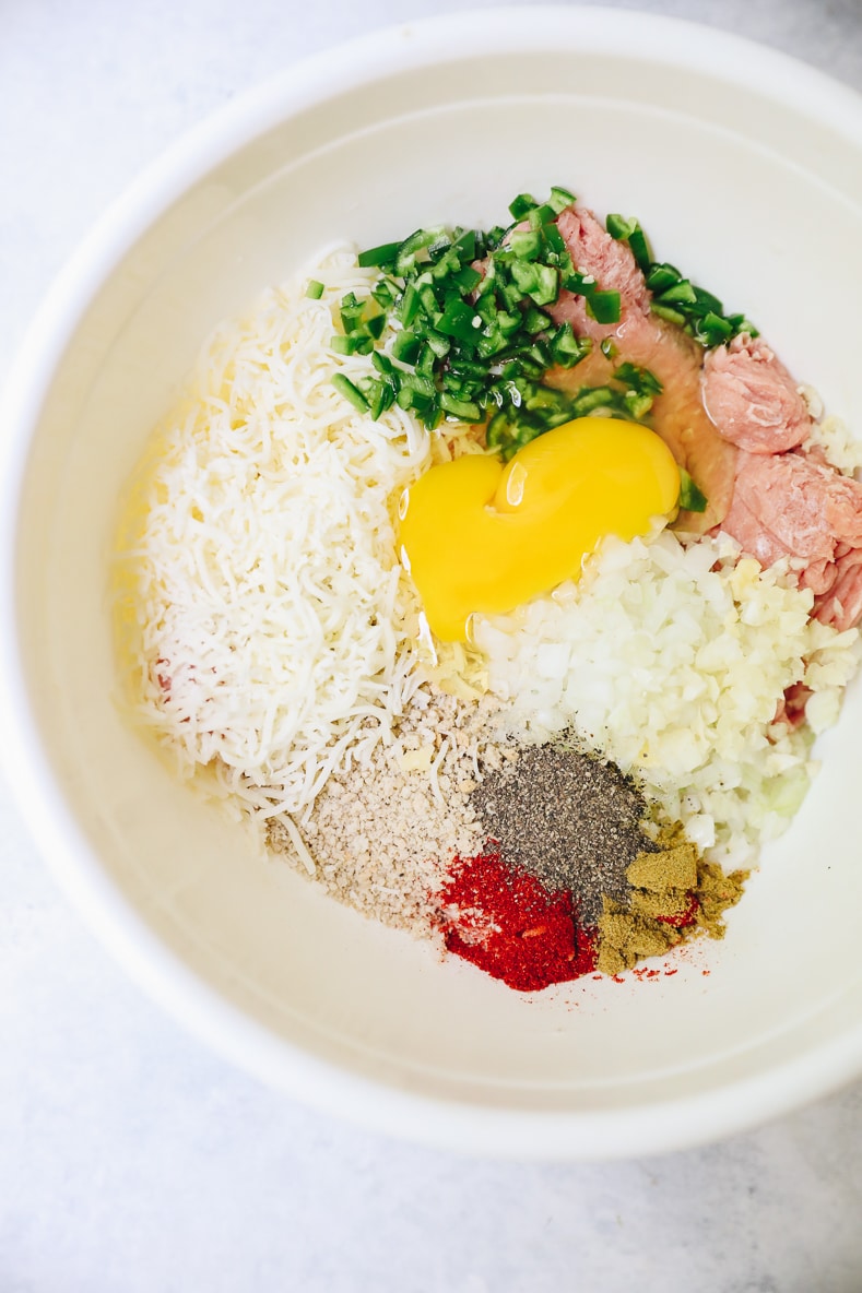 raw ingredients for turkey burgers in a white bowl.