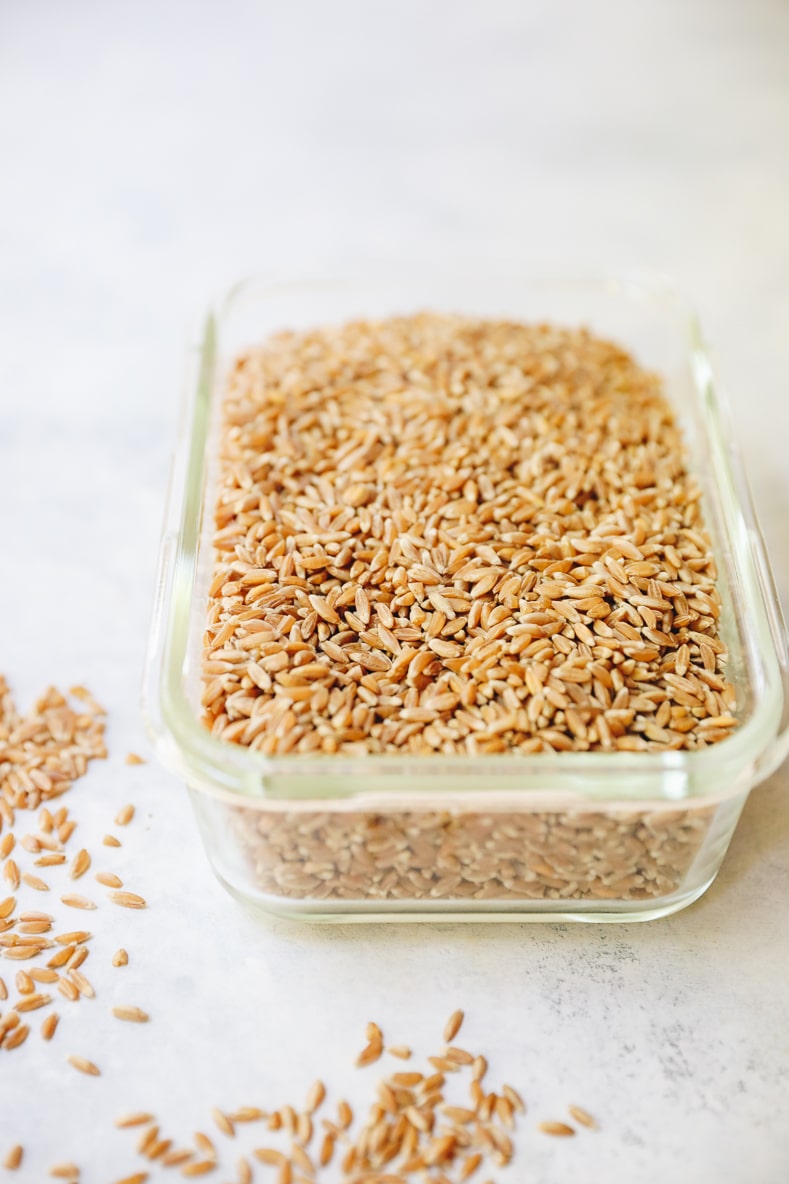 uncooked farro in a glass container