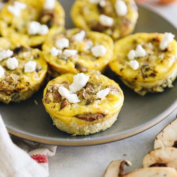 Plate of egg muffins topped with goat cheese.