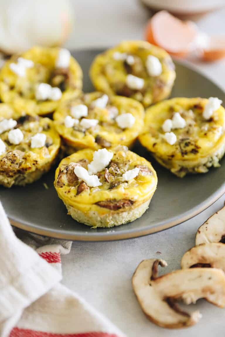 Plate of egg muffins topped with goat cheese.