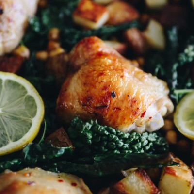a picture of a chicken thigh in a zesty lemon sauce with potatoes, chickpeas and kale
