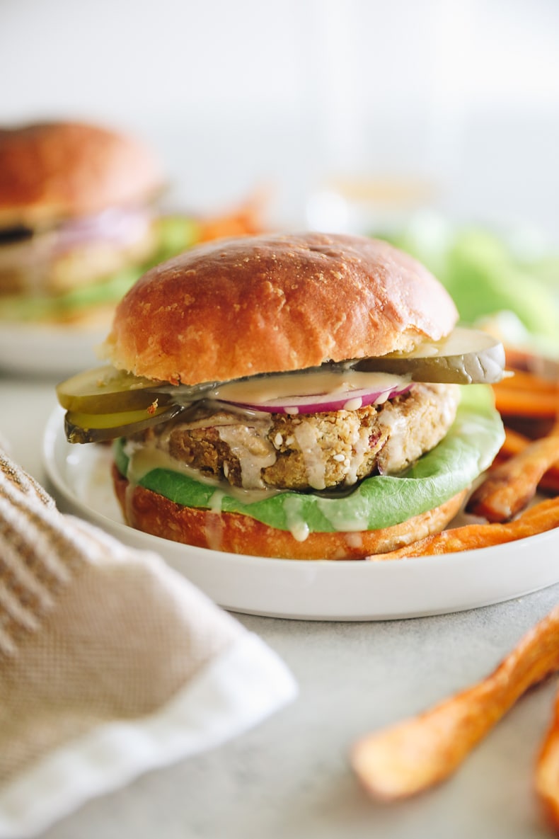 Fully loaded falafel burger topped with pickles, red onion and tahini on a burger bun