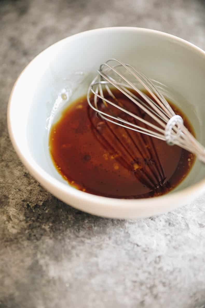 balsamic glaze in a bowl with a whisk.