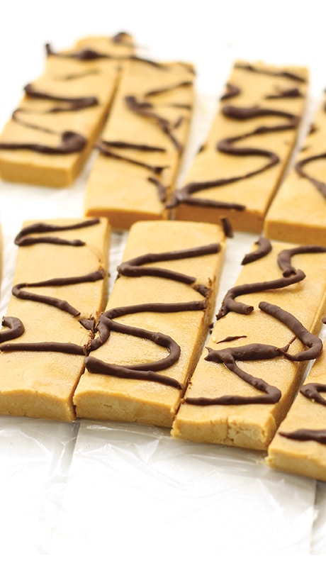 brown peanut butter protein bars with a chocolate drizzle on top