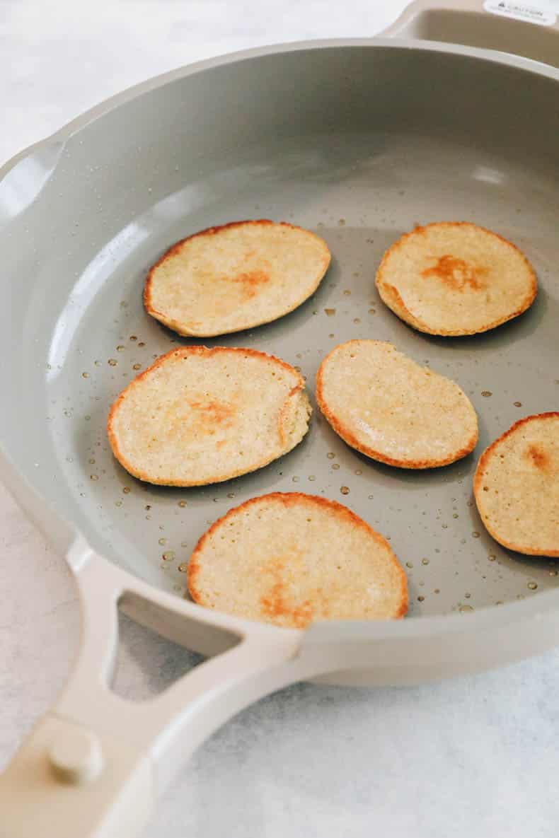 baby pancakes cooked in a skillet.