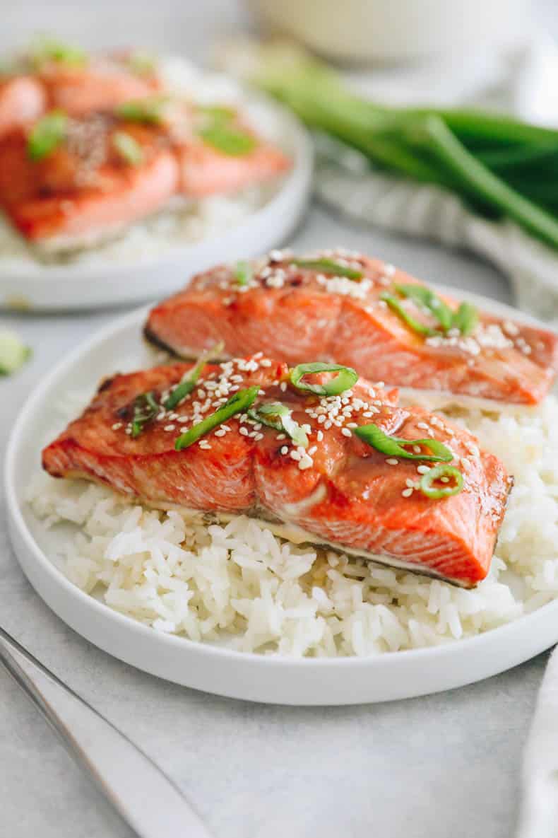 Miso salmon recipe with sesame seeds and spring onions on a bed of rice.