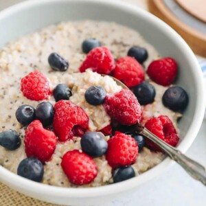 bowl of oatmeal with blueberries and raspberries and spoon.