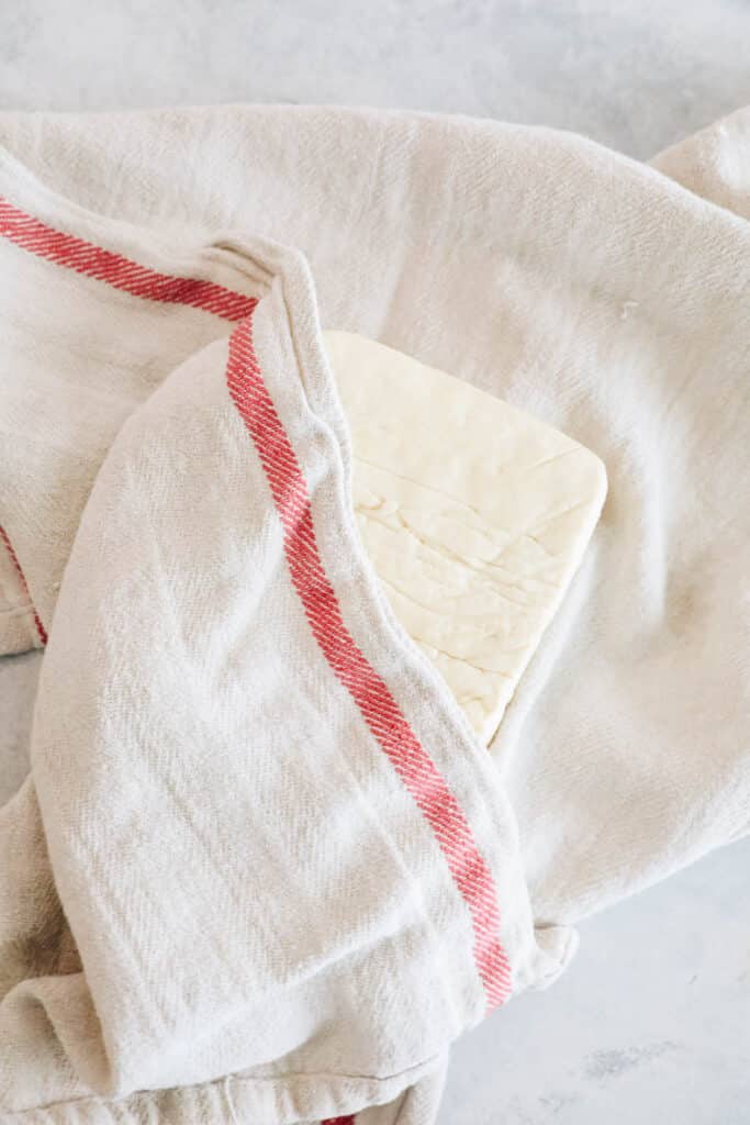 Pressing tofu in a dish towel