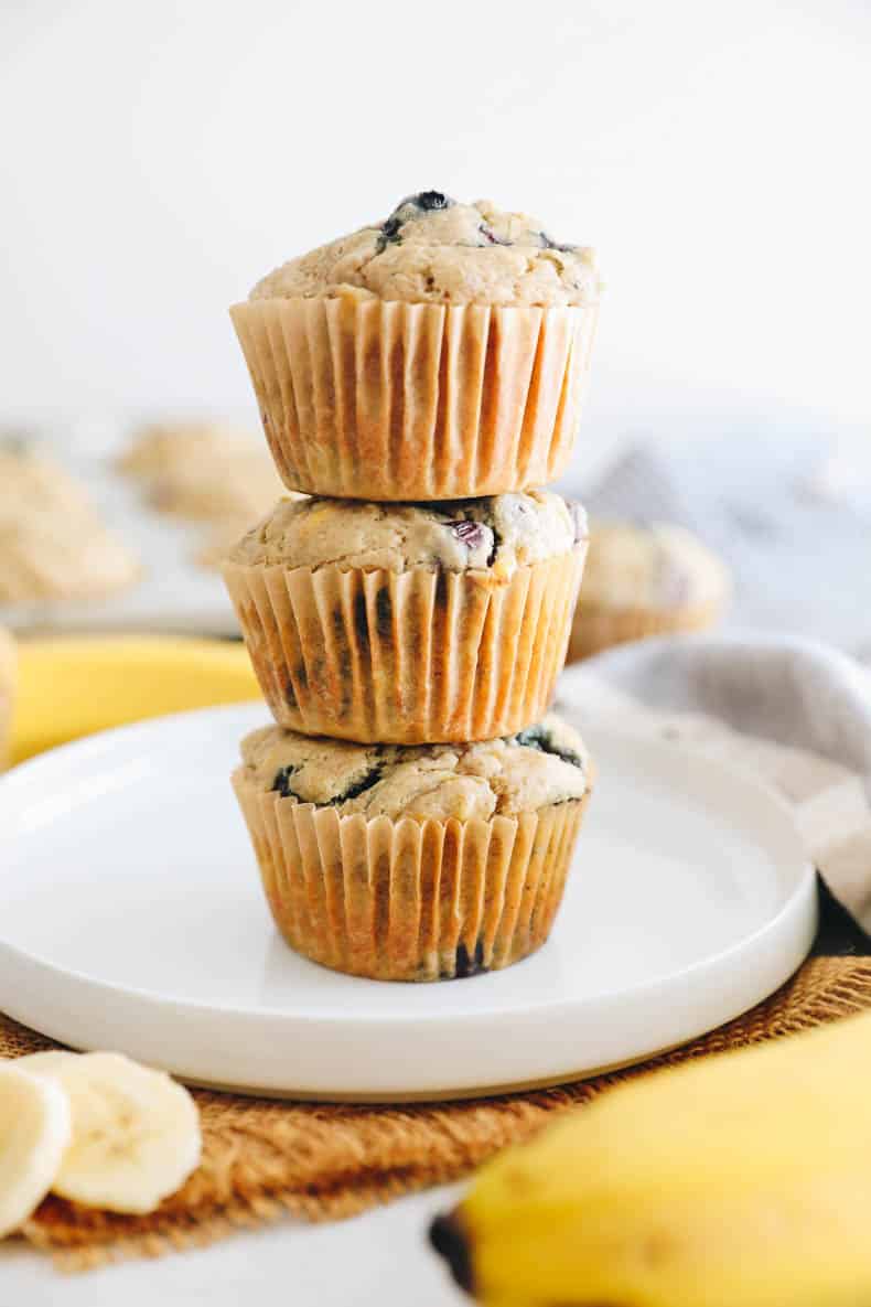 blueberry banana muffins stacked on a white plate