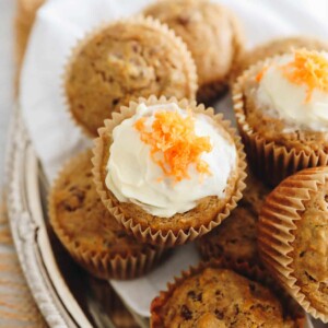 carrot cake muffins stacked on a plate.