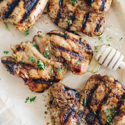 grilled honey mustard chicken on a plate sprinkled with parsley.