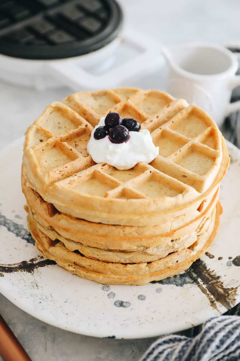 Stack of waffles topped with Greek yogurt and blueberries.