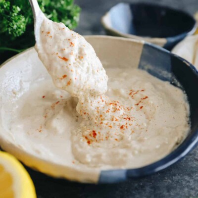tahini sauce in a bowl with a spoon.