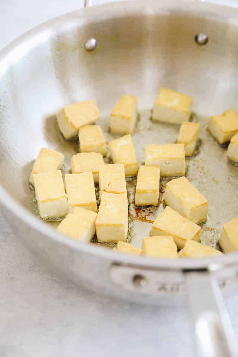 tofu cooking in a skillet.