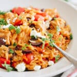 one-pot greek chicken orzo in a shallow white bowl.