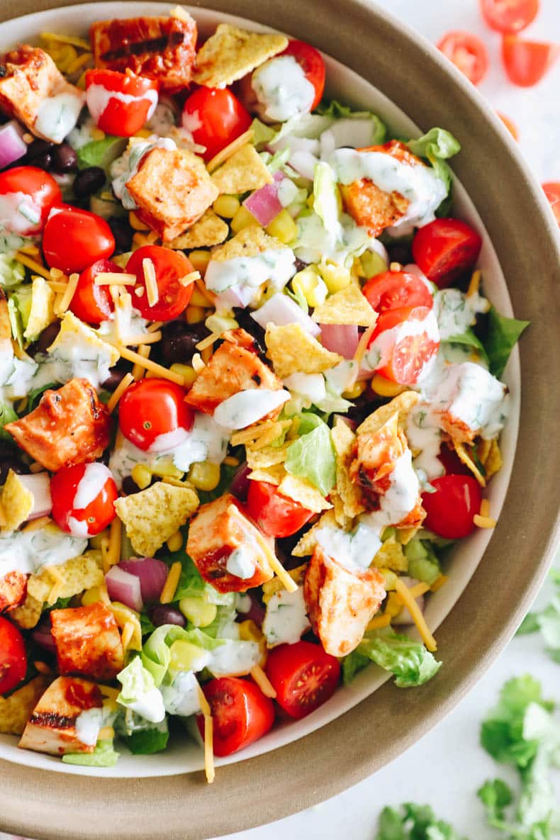 overhead image of BBQ chicken salad in a large serving bowl with greek yogurt ranch dressing.