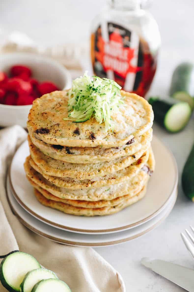 zucchini pancakes with maple syrup on a plate.