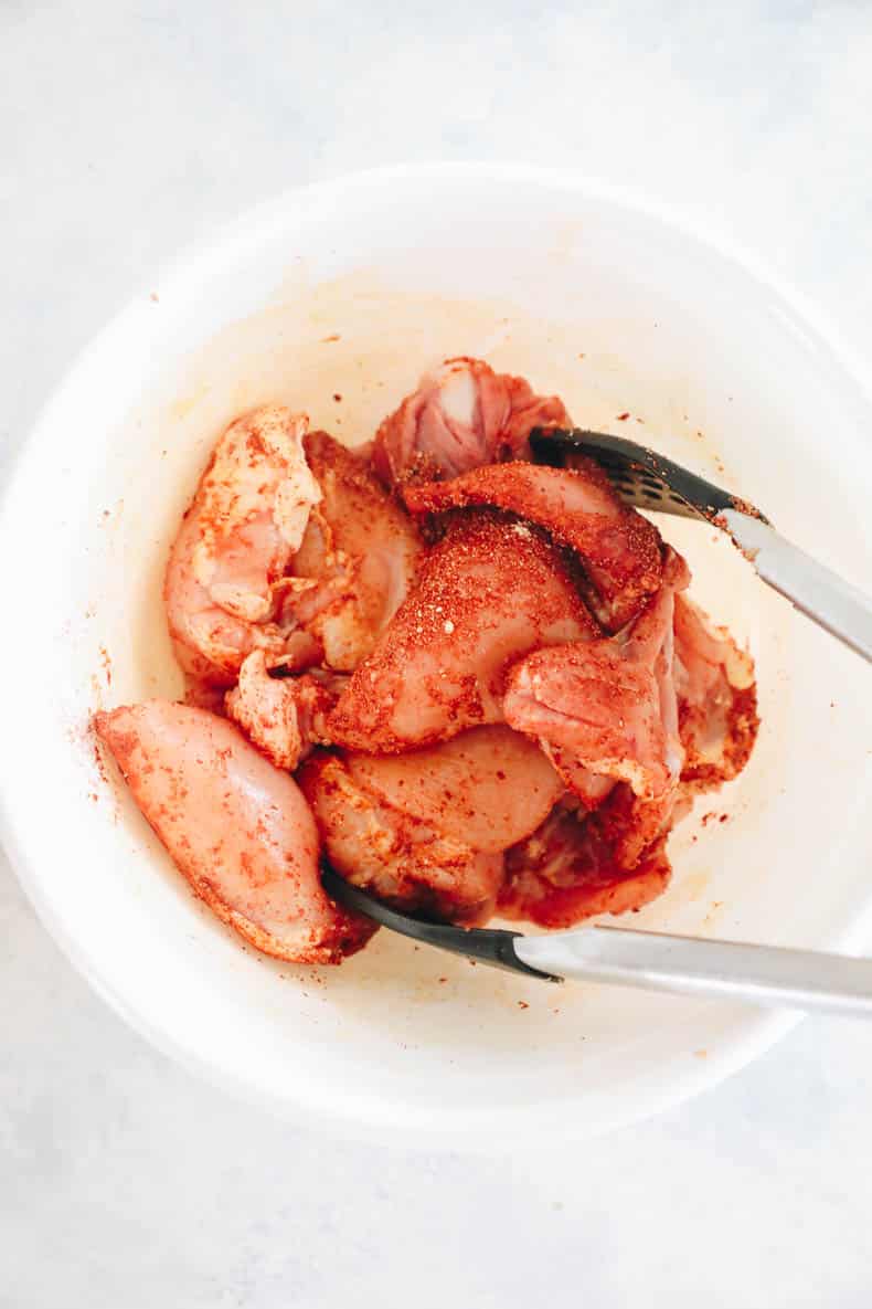 marinated chicken thighs in a white bowl