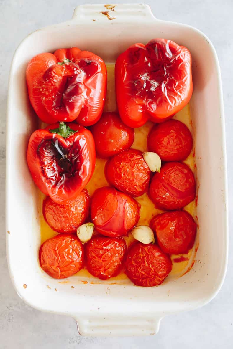 roasted red peppers, tomatoes and garlic in a baking dish.