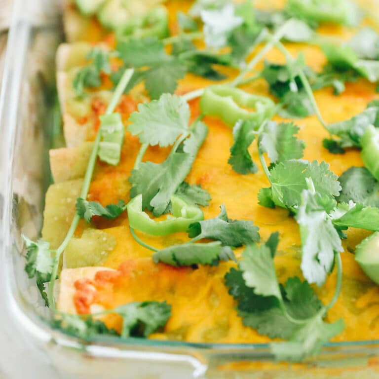 green chicken enchiladas in a glass pyrex dish.