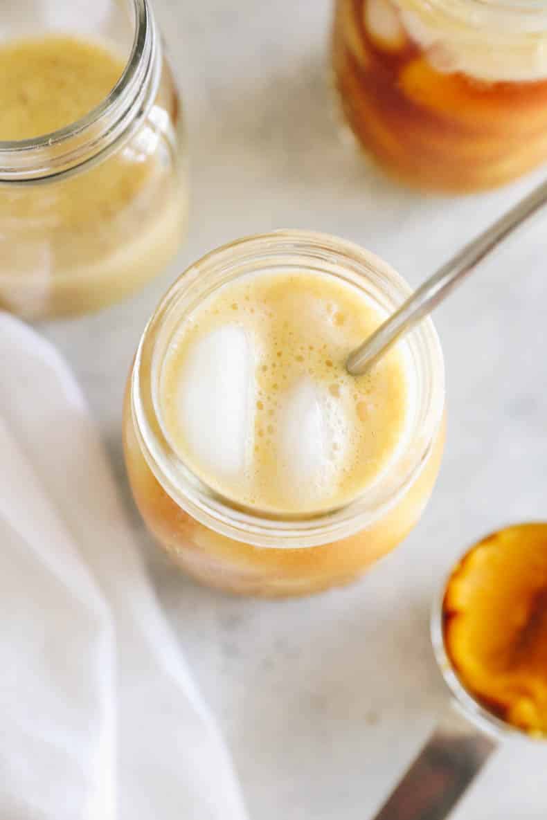 pumpkin spice cold brew over ice in a mason jar.