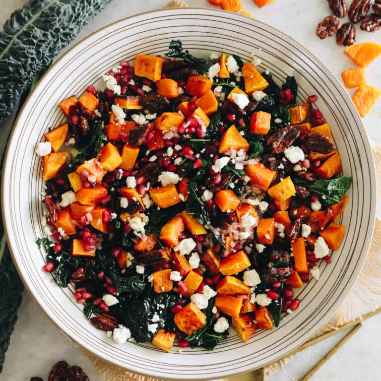 Fall butternut squash salad over a bed of kale with cheese, pomegranate seeds and an apple cider vinegar dressing.