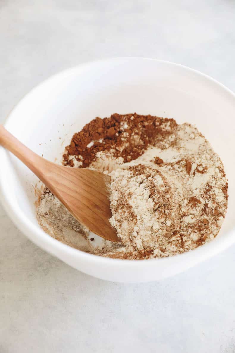 Dry ingredients for pumpkin brownies in a white mixing bowl.