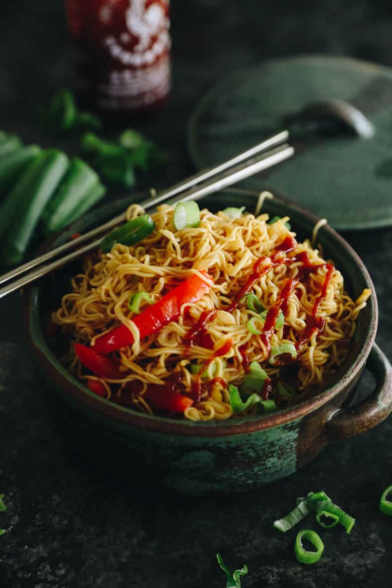 the best spicy ramen noodles prepared in a green bowl with chopsticks.