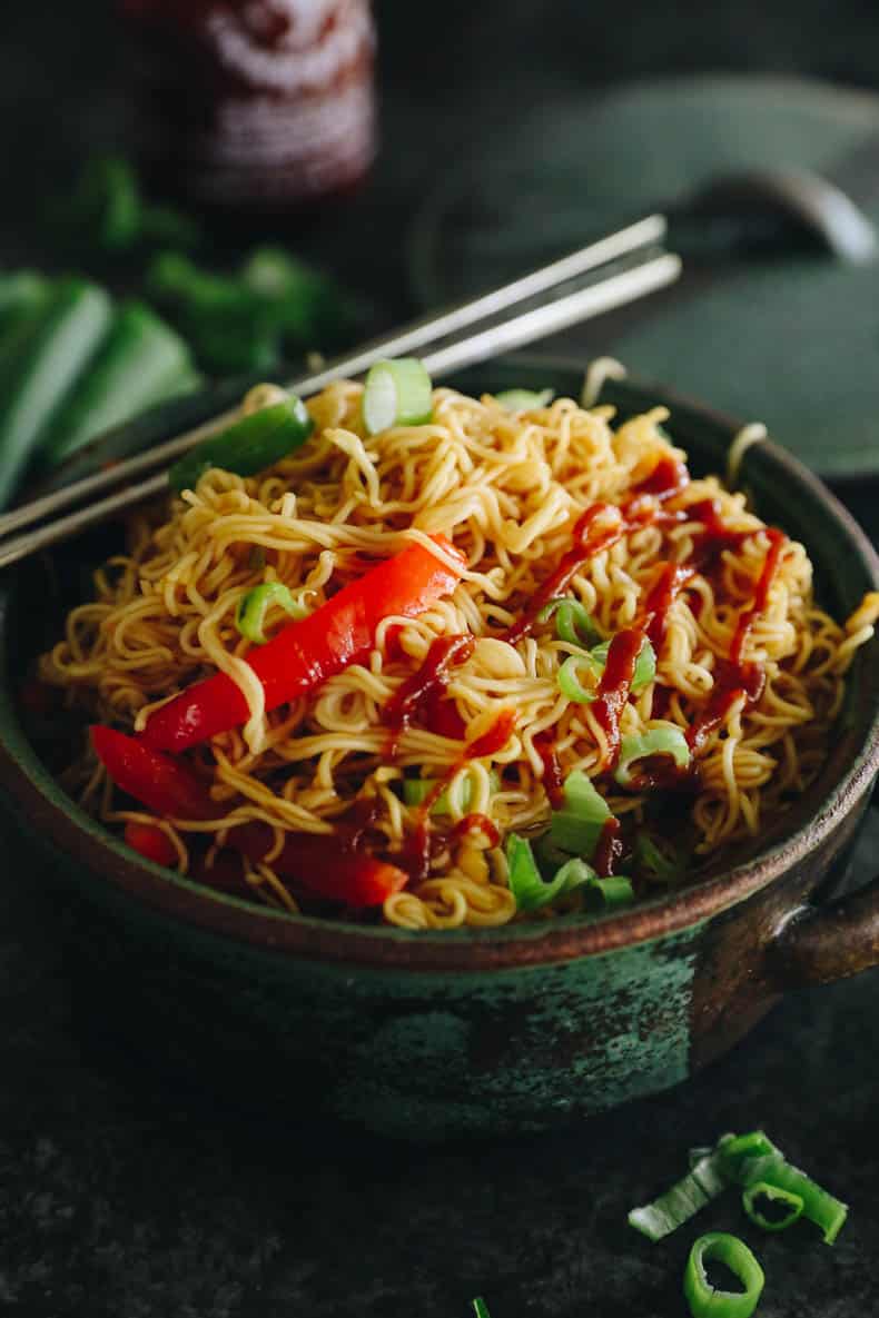 spicy ramen noodles in a green bowl with chopsticks.