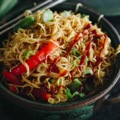 close-up of spicy ramen noodles in a bowl with chopsticks.