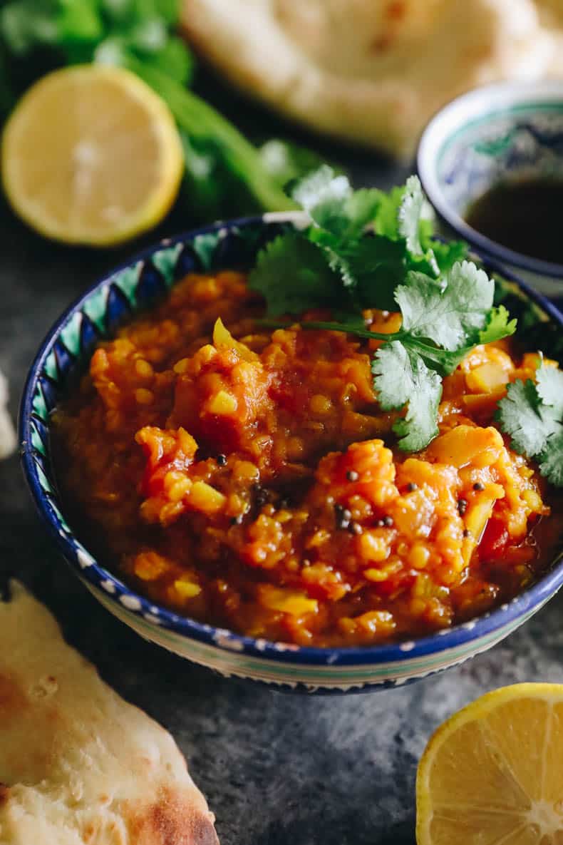 close-up image of root vegetable dal topped with spice oil and cilantro.