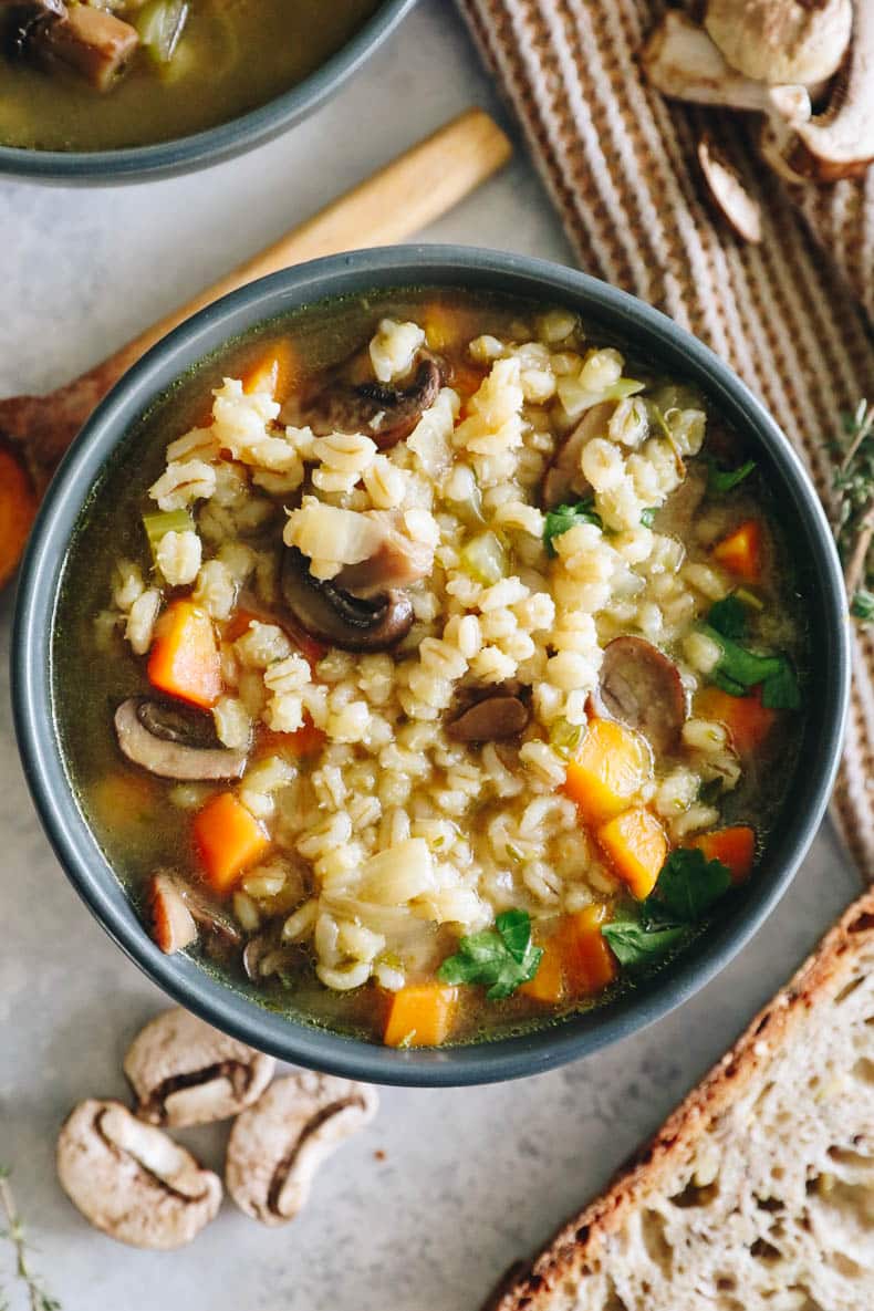 overhead image of mushroom barley soup in a blue bowl.