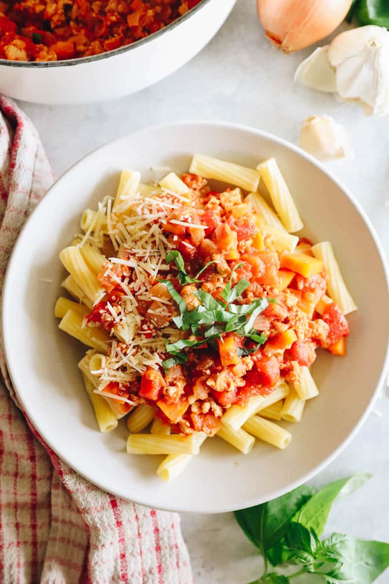 Rigatoni bolognese with chopped basil and parmesan cheese.