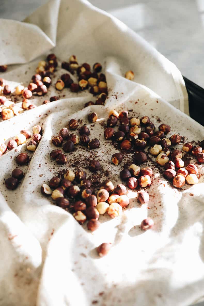 Removing the skins from toasted hazelnuts on a dish towel.