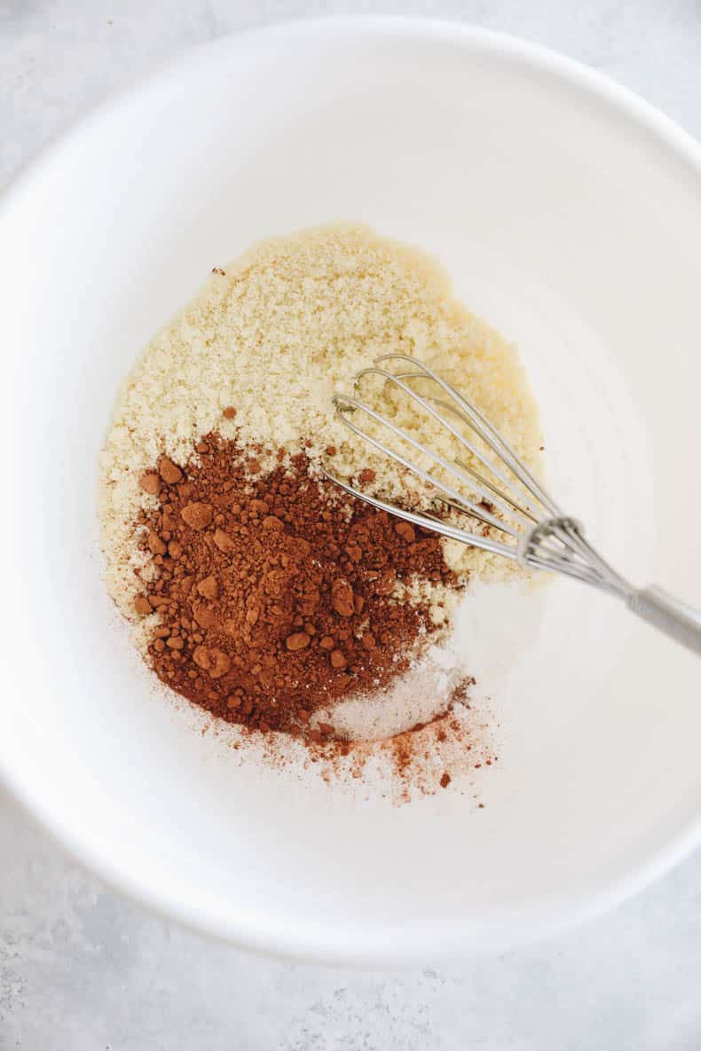 dry ingredients for brownies in a white bowl with a whisk