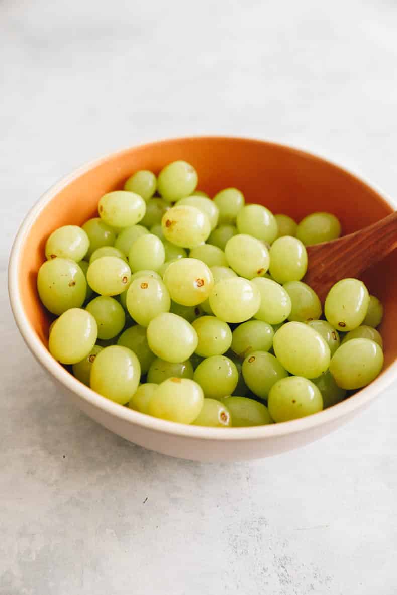 green grapes in a brown bowl.